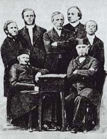 Abbildung der männlichen Diakonen, die an einem Tisch stehen und sitzen